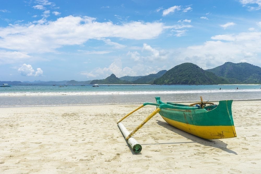 Traditional wooden boat park at sea shore with cloudy skies at South Lombok island, Indonesia